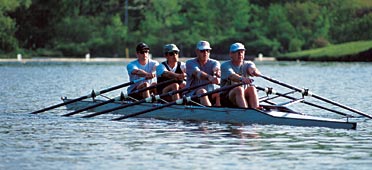 photo of four rowers in scull on river